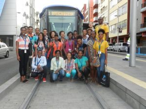 Monitores y estudiantes de CampusÁfrica posan junto al tranvía en la parada La Trinidad. 