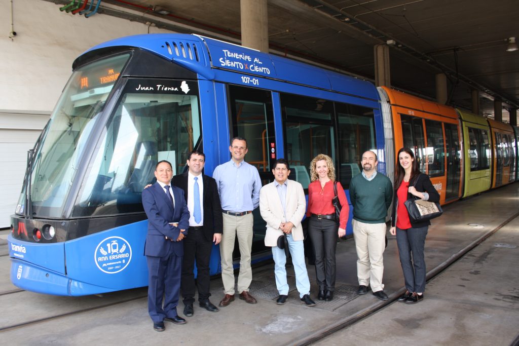 Autoridades de Metrotenerife y de las delegaciones de Colombia y Perú posan en cocheras, delante de un tranvía