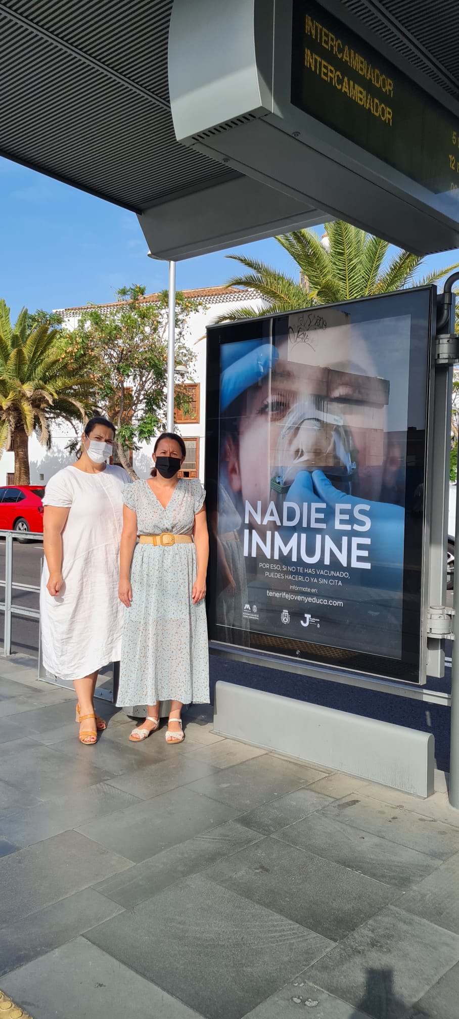 Autoridades del Cabildo de Tenerife junto al cartel de la campaña en la parada Fundación.