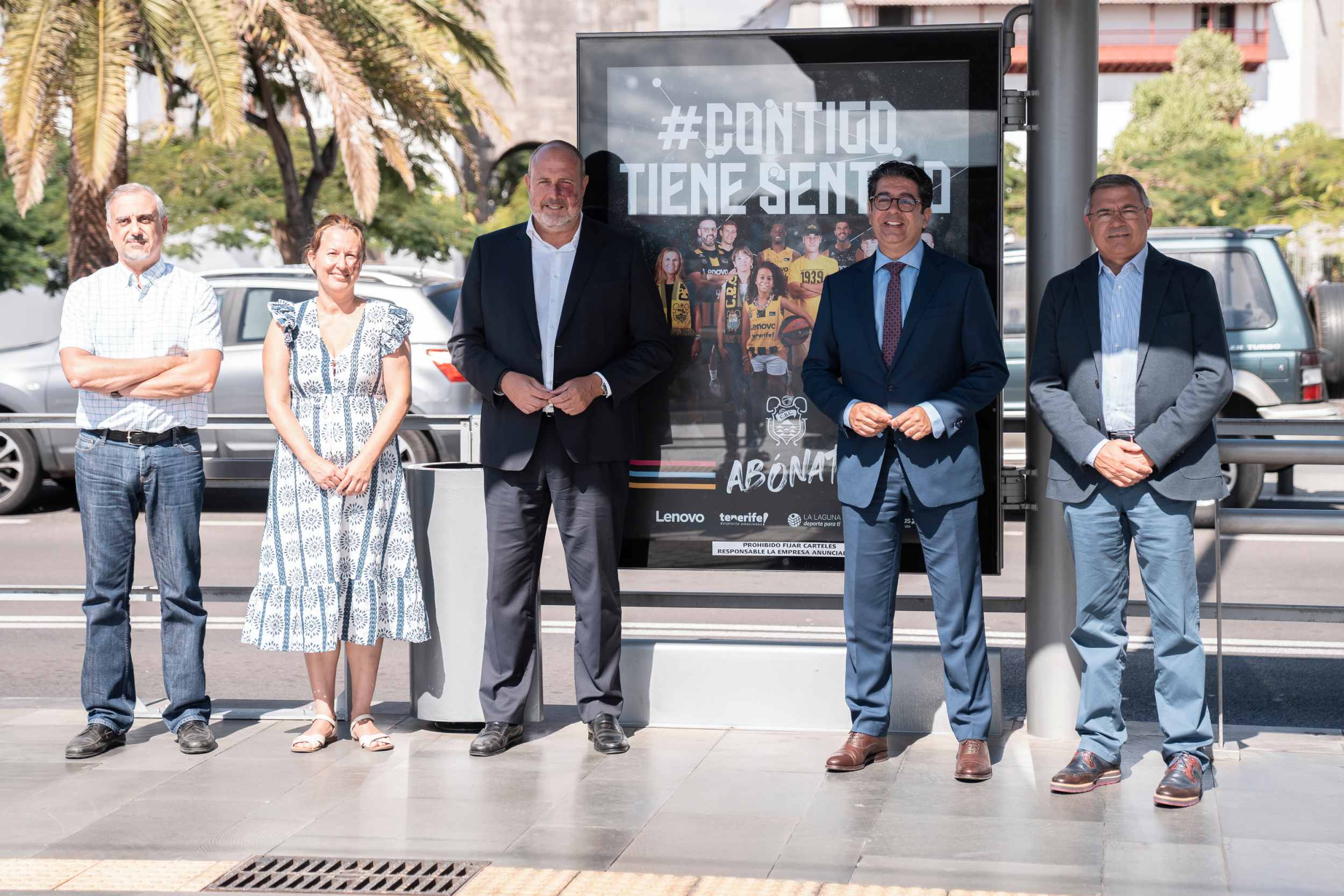 Autoridades del Cabildo Insular, Metrotenerife y del Club Baloncesto Canarias junto a la imagen de la campaña en una de las paradas del tranvía.